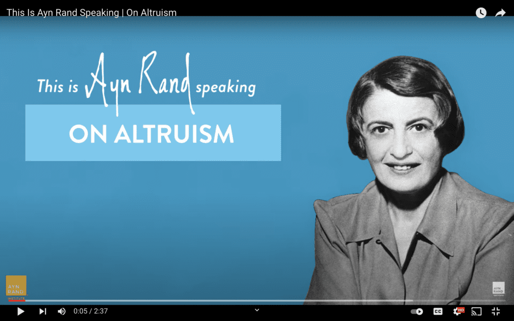 A woman is smiling for the camera in front of an altruism sign.