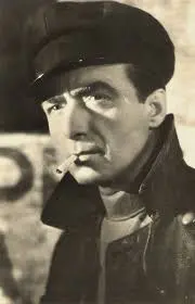 A man in a hat and jacket smoking.