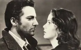 A man and woman face to face in an old photo.