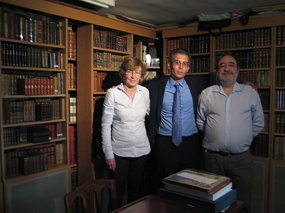 Three people in a wood-paneled library