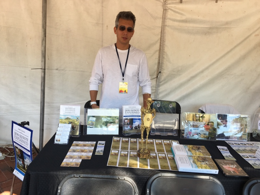 Man wearing sunglasses behind promotional booth table