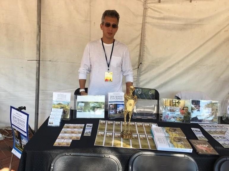 Vendor at booth displaying jewelry and awards