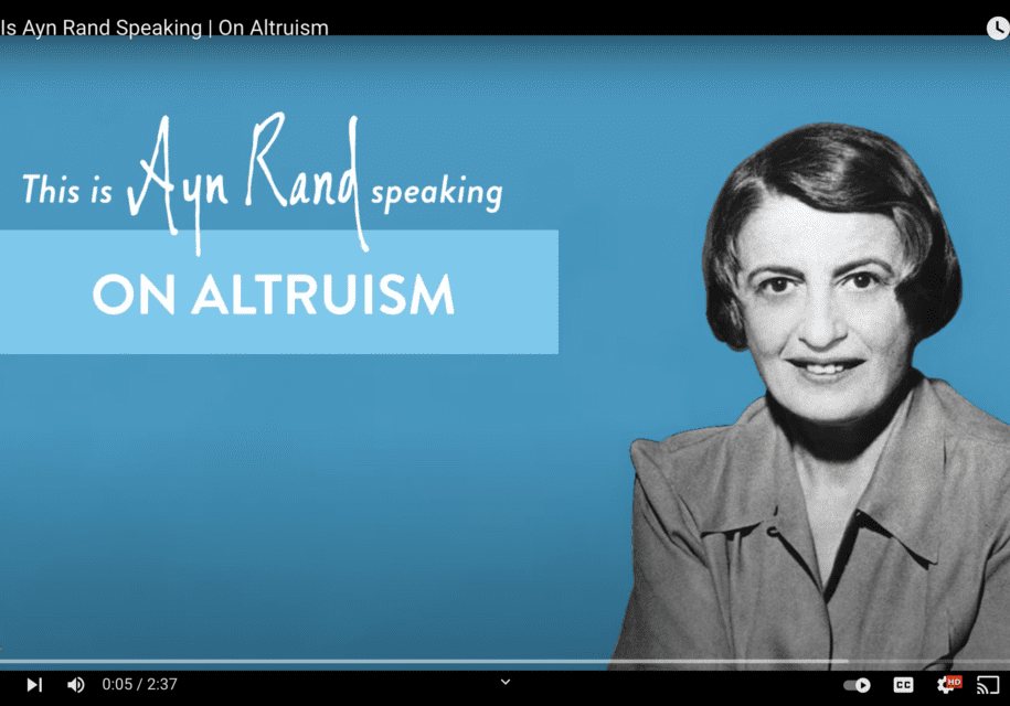 A woman is smiling for the camera in front of an altruism sign.